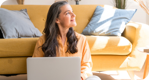 Mujer con laptop sentada, Seguro Hospitalario Quirúrgico UC CHRISTUS